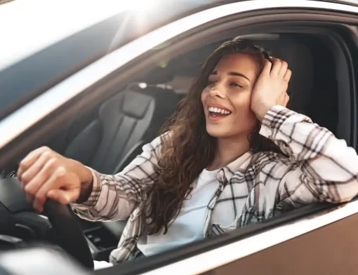 Motorista sorrindo ao volante de um carro alienado, ilustrando veículo em regime de alienação fiduciária