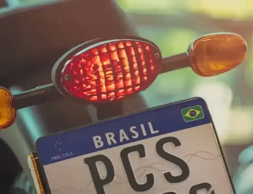 Placa Mercosul instalada em motocicleta vista por trás, com foco na matrícula e lanternas
